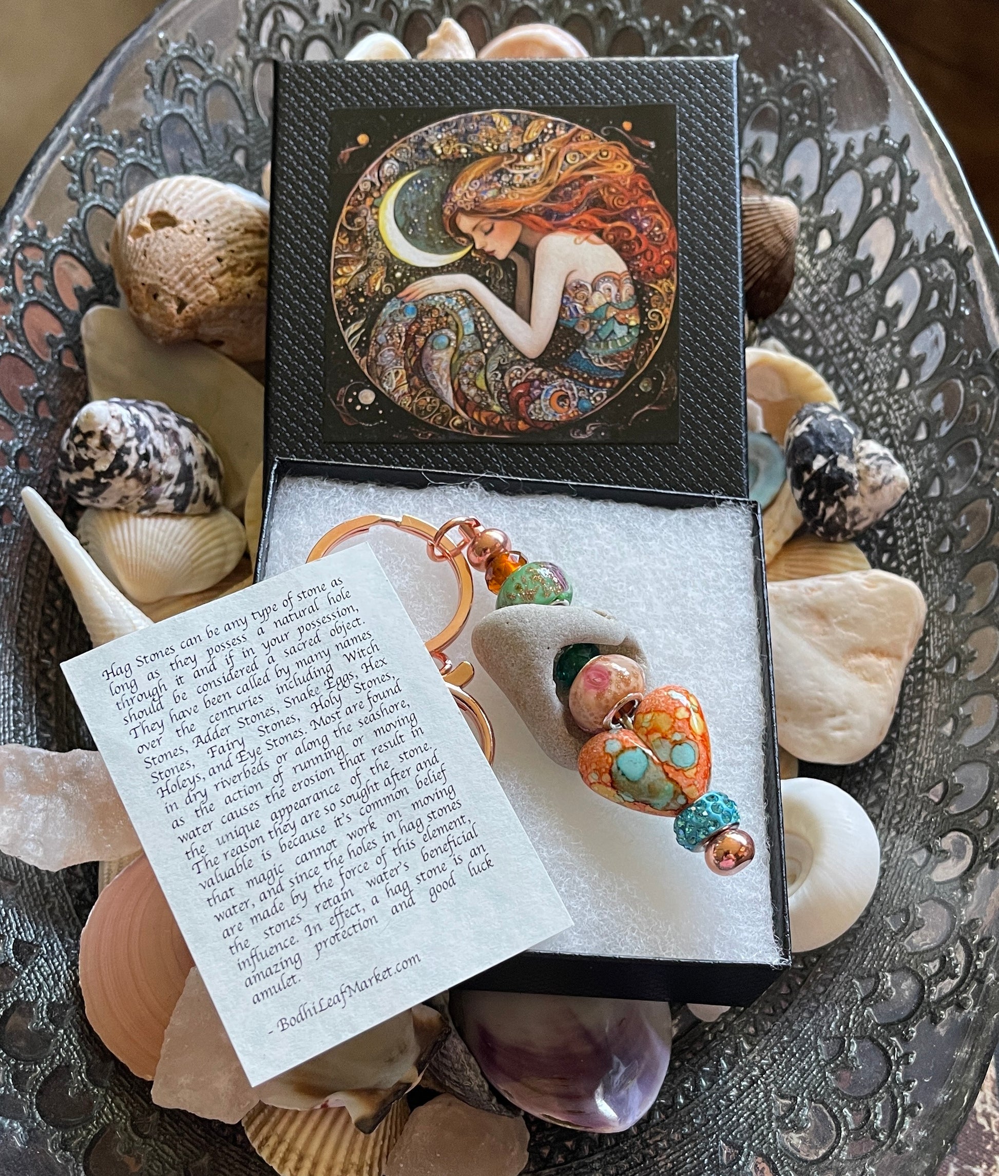 Earring set in a decorative box with seashells and a poem on a textured surface