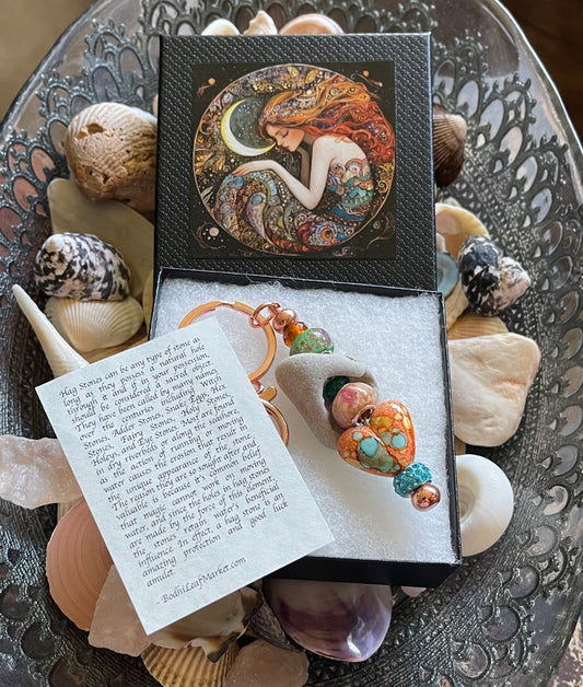 Earring set in a decorative box with seashells and a poem on a textured surface