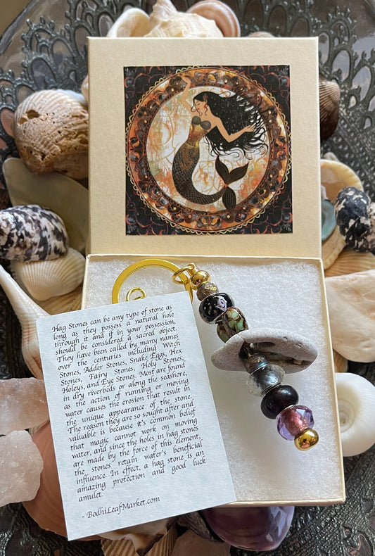 Mermaid-themed necklace in a decorative box with seashells in the background