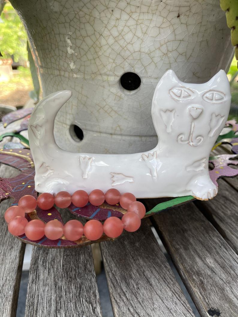 This crazy cat is adorable! Made of clay and then stamped and painted white, he is a wonderful vintage piece. I am throwing in a lovely strawberry quartz bracelet for extra cat love!  Measures approx 6" W x 4" H.